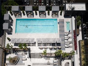 Los Angeles apartment for rent - A large swimming pool surrounded by lounge chairs and umbrellas.
