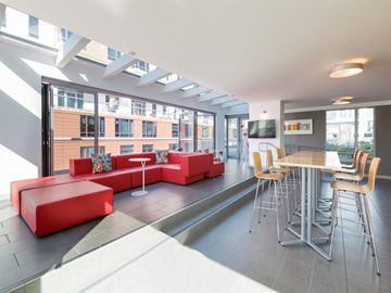 San Francisco apartment for rent - A modern living room with a red couch and a dining table.