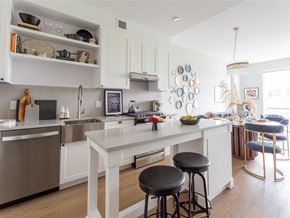 Washington apartment for rent - a large white kitchen with a white island and bar stools