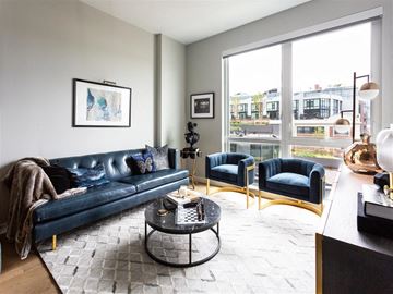 Washington apartment for rent - A living room with a blue couch and a coffee table.