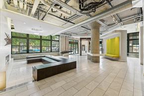 Washington apartment for rent - the lobby of a large office building with a lobby area and a yellow wall