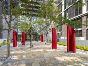 Washington apartment for rent - A modern outdoor courtyard featuring unique red sculptures, surrounded by lush greenery—perfect for relaxation and social gatherings.