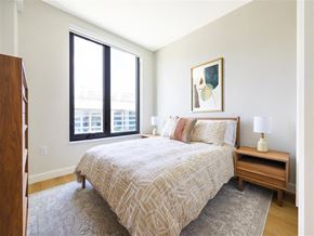 Washington apartment for rent - A bedroom with a bed, nightstand, and a painting on the wall.