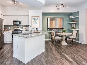 Miramar apartment for rent - A kitchen with a white island and a dining table with chairs.