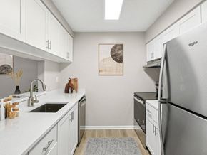 Tampa apartment for rent - A kitchen with white cabinets and a fridge.