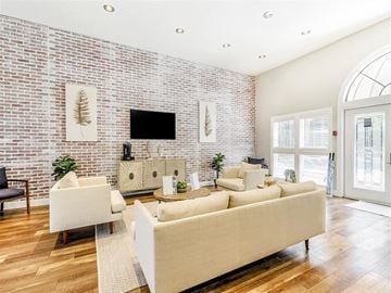 Tampa apartment for rent - A living room with a white couch and a brick wall.