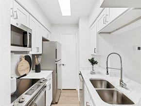Tampa apartment for rent - A kitchen with white cabinets and stainless steel appliances.