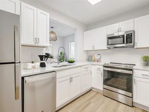 Tampa apartment for rent - a kitchen with white cabinets and stainless steel appliances
