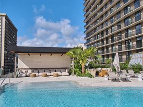 Honolulu apartment for rent - a hotel pool with a large building in the background