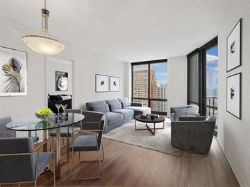 Chicago apartment for rent - A modern living room with a glass table and grey couch.