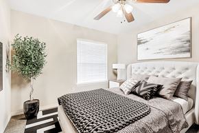 Mckinney apartment for rent - A bedroom with a large bed and a ceiling fan.