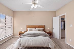 Garland apartment for rent - A bedroom with a large bed and a ceiling fan.