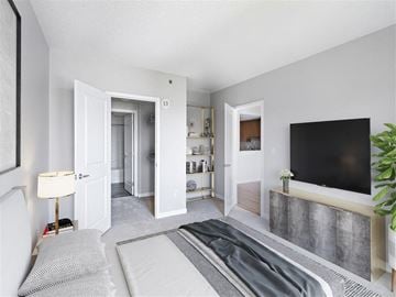 Cambridge apartment for rent - A modern living room with a grey carpet and a black television.