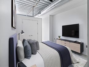 Cambridge apartment for rent - A bedroom with a bed, a nightstand, a television, and a window with a view of the sky.
