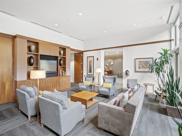 Cambridge apartment for rent - A modern living room with grey sofas and a wooden entertainment unit.