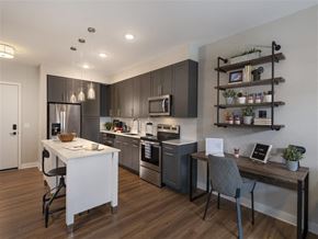 Baltimore apartment for rent - A modern kitchen with dark brown cabinets and a white island.