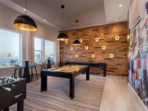 Baltimore apartment for rent - A billiard table is in the middle of a room with a wooden wall and a pool table on the left.