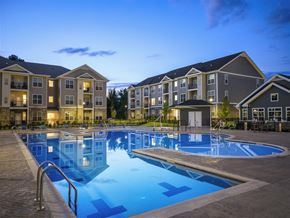 Mt Laurel Township apartment for rent - an empty pool at dusk in front of an apartment building