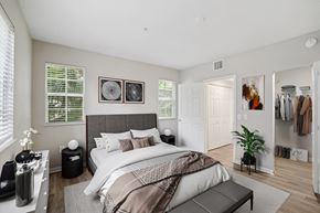 Miramar apartment for rent - A bedroom with a large bed and a clothing rack.