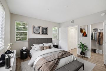 Miramar apartment for rent - A bedroom with a large bed and a clothing rack.