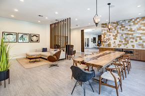 Las Vegas apartment for rent - Resident lounge with a modern dining room with a long wooden table and chairs.