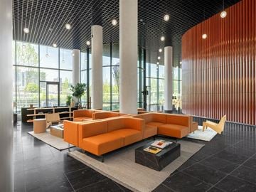 Bronx apartment for rent - A modern living room with orange furniture and a black floor.