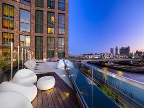 Bronx apartment for rent - a rooftop terrace with a view of the city and a river