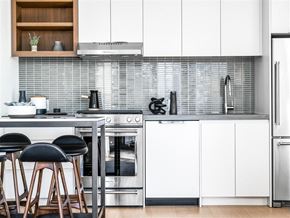 Brooklyn apartment for rent - a kitchen with white cabinets and a counter with chairs
