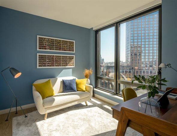 Brooklyn apartment for rent - A living room with a white couch and a large window overlooking the city.