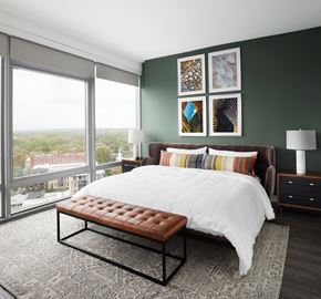Arlington apartment for rent - A bedroom with a large bed and a bench in front of it.