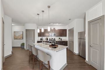 Woodstock apartment for rent - A modern kitchen with a white island and wooden floors.