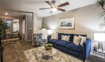Phoenix apartment for rent - A living room with a blue couch and a ceiling fan.