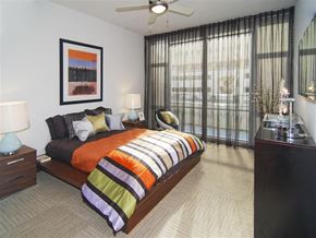 Dallas apartment for rent - A bedroom with a bed, nightstands, and a ceiling fan.