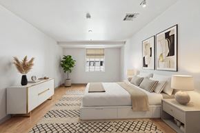 Dallas apartment for rent - A bedroom with a large bed, a nightstand, and a dresser.