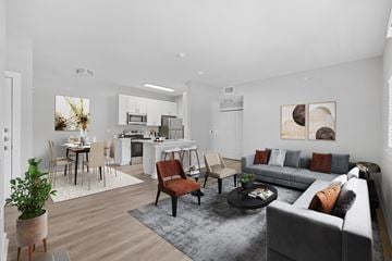 Mckinney apartment for rent - A modern living room with a grey sofa and a dining table with chairs.