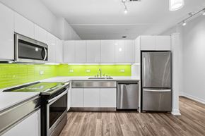 Dallas apartment for rent - A modern kitchen with stainless steel appliances and wooden floors.
