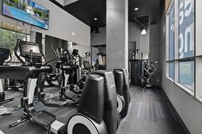 Los Angeles apartment for rent - A gym with treadmills, elliptical machines, and a television.