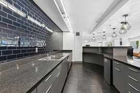 Los Angeles apartment for rent - A modern kitchen with dark grey cabinets and a black tile backsplash.