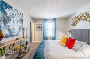 Las Vegas apartment for rent - a bedroom with a large bed and a window with blue curtains