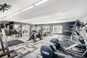 Columbus apartment for rent - a gym with cardio machines and weights on a checkered floor