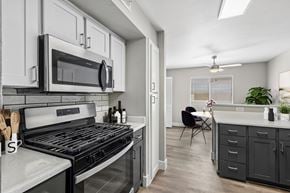 Las Vegas apartment for rent - A modern kitchen with a black stove top oven and white cabinets.