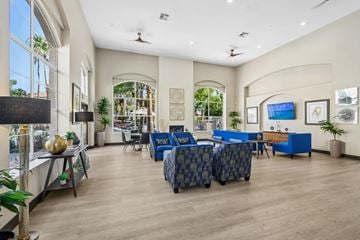 Las Vegas apartment for rent - A spacious living room with a blue sofa set and a television mounted on the wall.