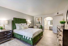 Las Vegas apartment for rent - a bedroom with a green bed and a bathroom in the background