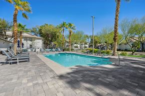 Las Vegas apartment for rent - A swimming pool surrounded by palm trees and lounge chairs.