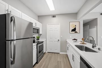 Las Vegas apartment for rent - A modern kitchen with a stainless steel refrigerator and white cabinets.