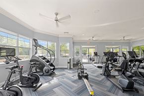 Charlotte apartment for rent - Cardio equipment section of the fitness center with windows wrapping the room