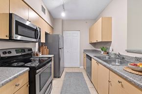 Miramar apartment for rent - A kitchen with a black stove top oven and a black refrigerator.