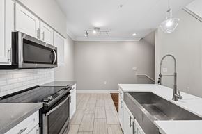 Houston apartment for rent - A modern kitchen with a black oven and white cabinets.