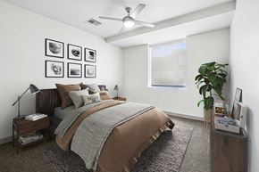 Dallas apartment for rent - A bedroom with a large bed and a ceiling fan.