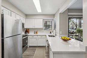 Tampa apartment for rent - A modern kitchen with white cabinets and appliances.